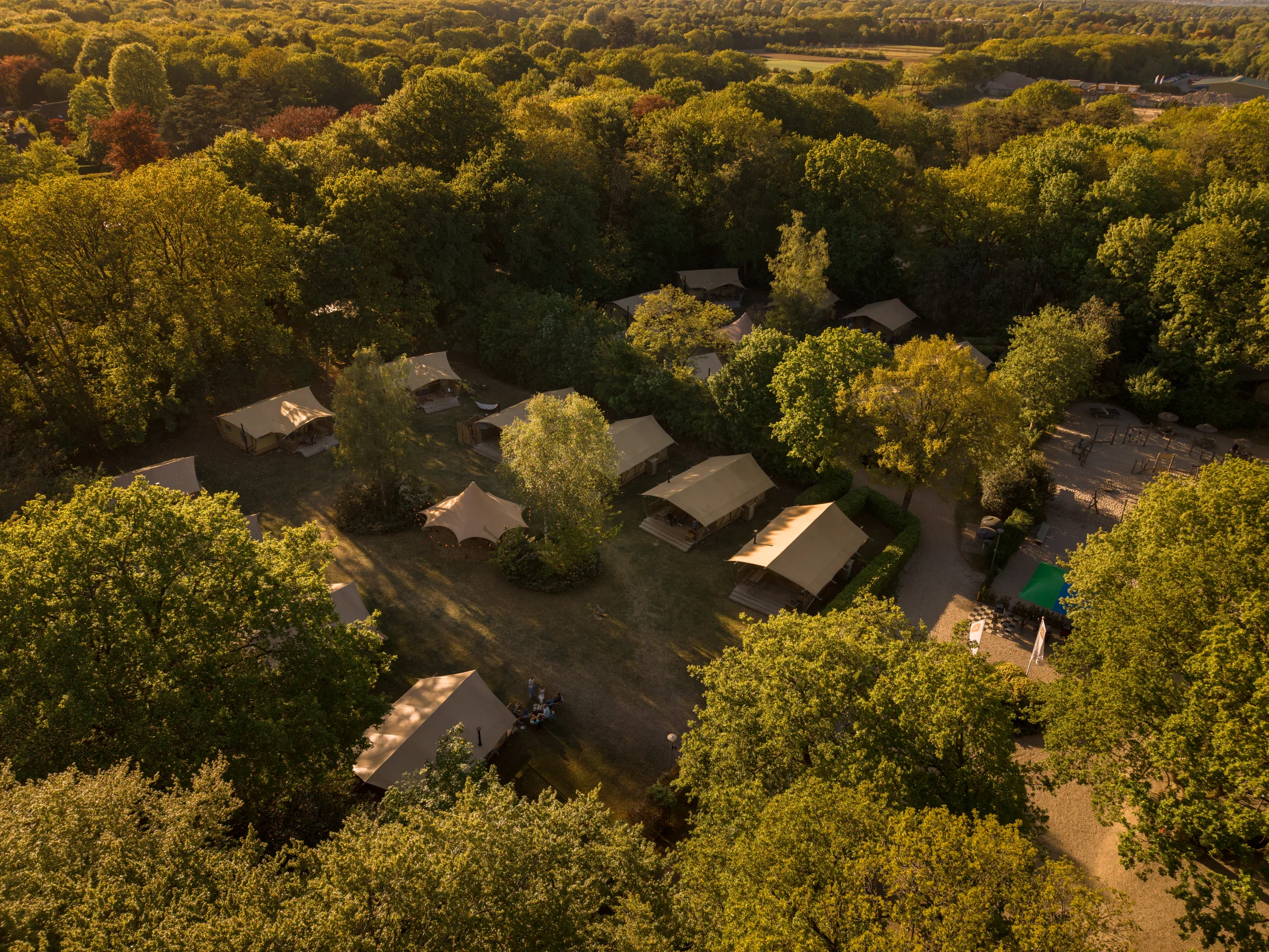 Luchtfoto van de glamping tenten van Buytenplaats Gooise Heide tussen de bomen