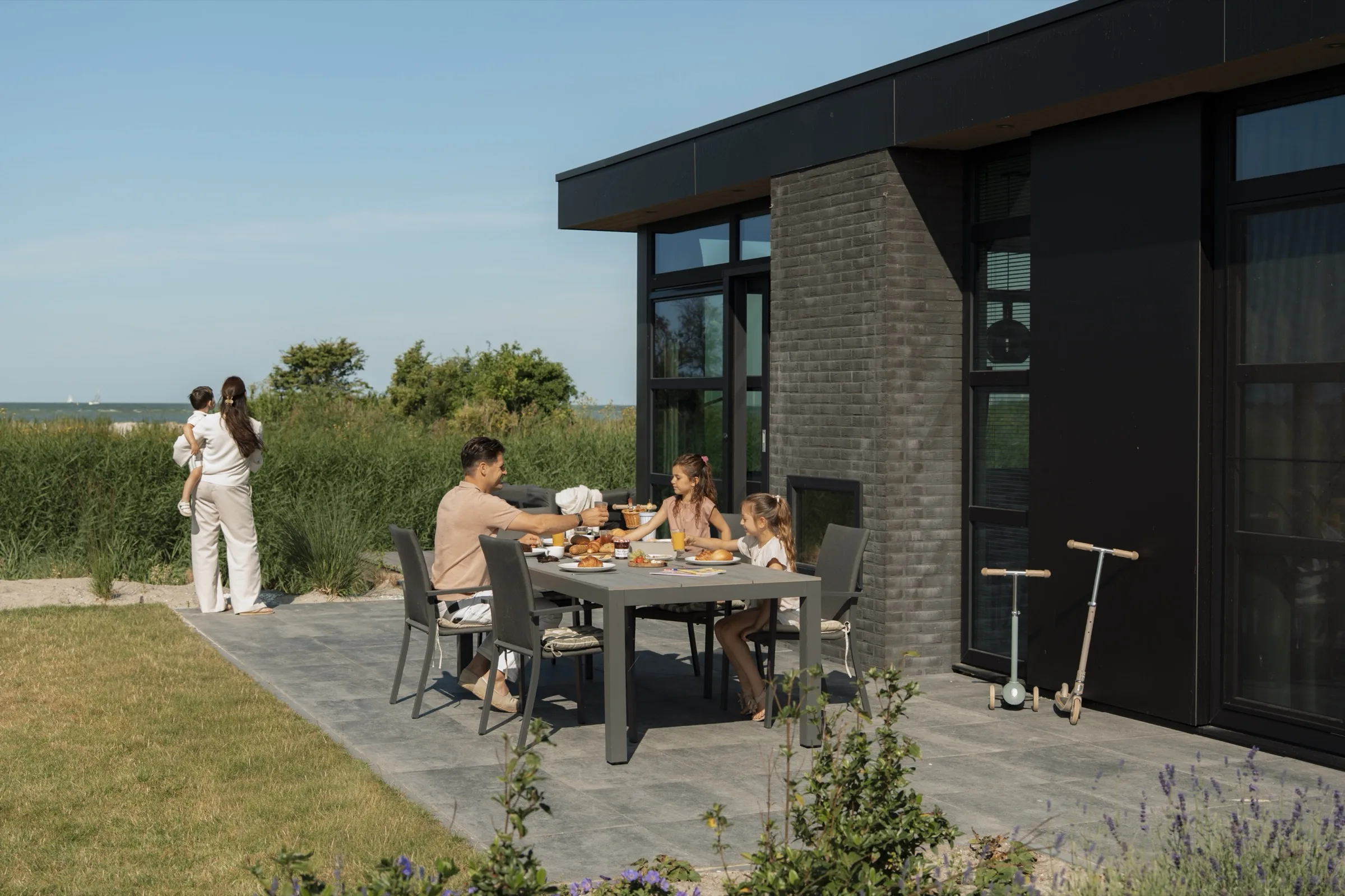 Gezin ontbijt op het terras van een vakantiewoning van MarinaPark Soal met uitzicht op het IJsselmeer