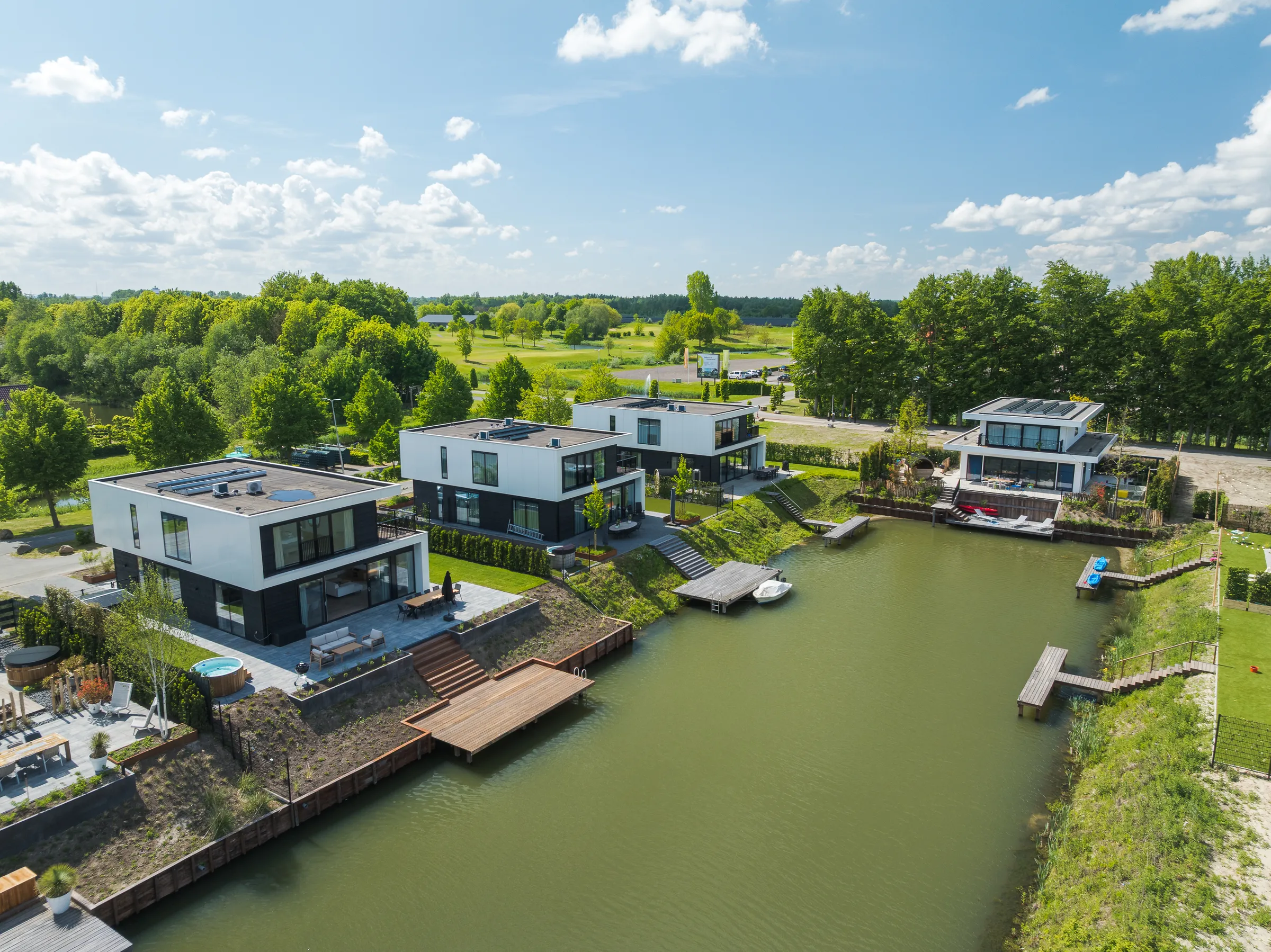 Luchtfoto van moderne villa's met steigers aan het water bij Harderwold